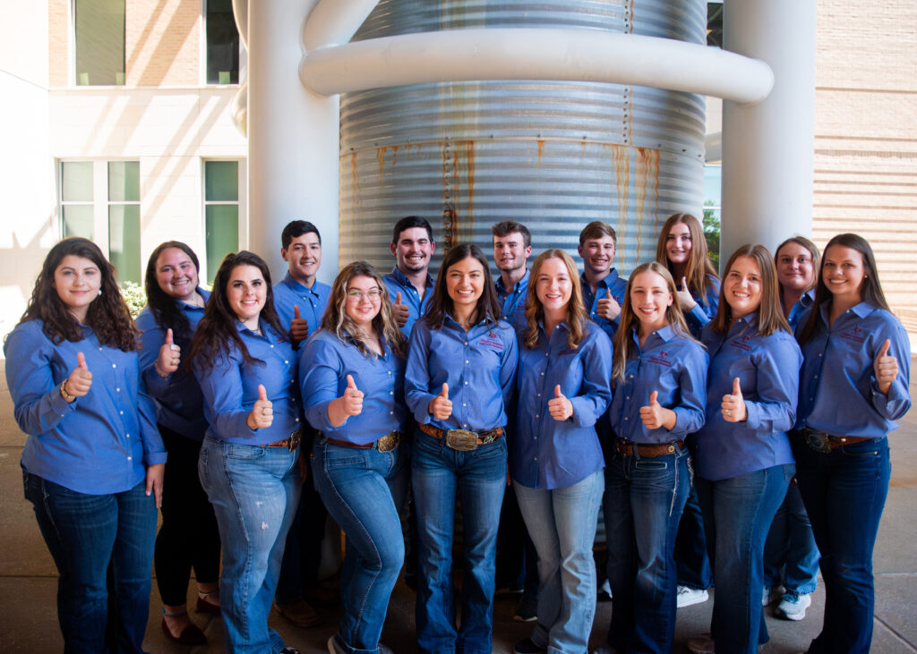 Aggie Poultry Ambassadors standing together for a picture while wearing the same team blue shirts.